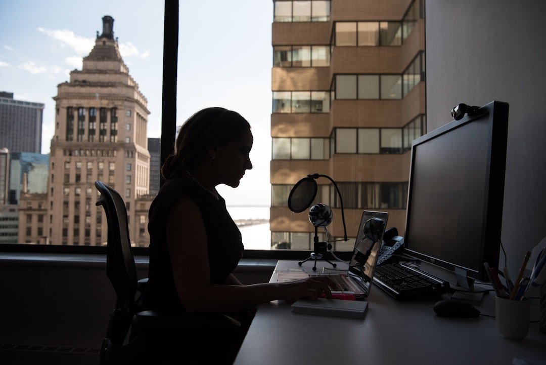 woman-sitting-in-front-of-desk-with-computer-monitor-and-keyboard-on-top-eaxpbb4vzku